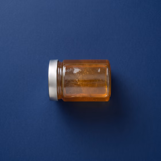 Glass jar of honey with metal lid